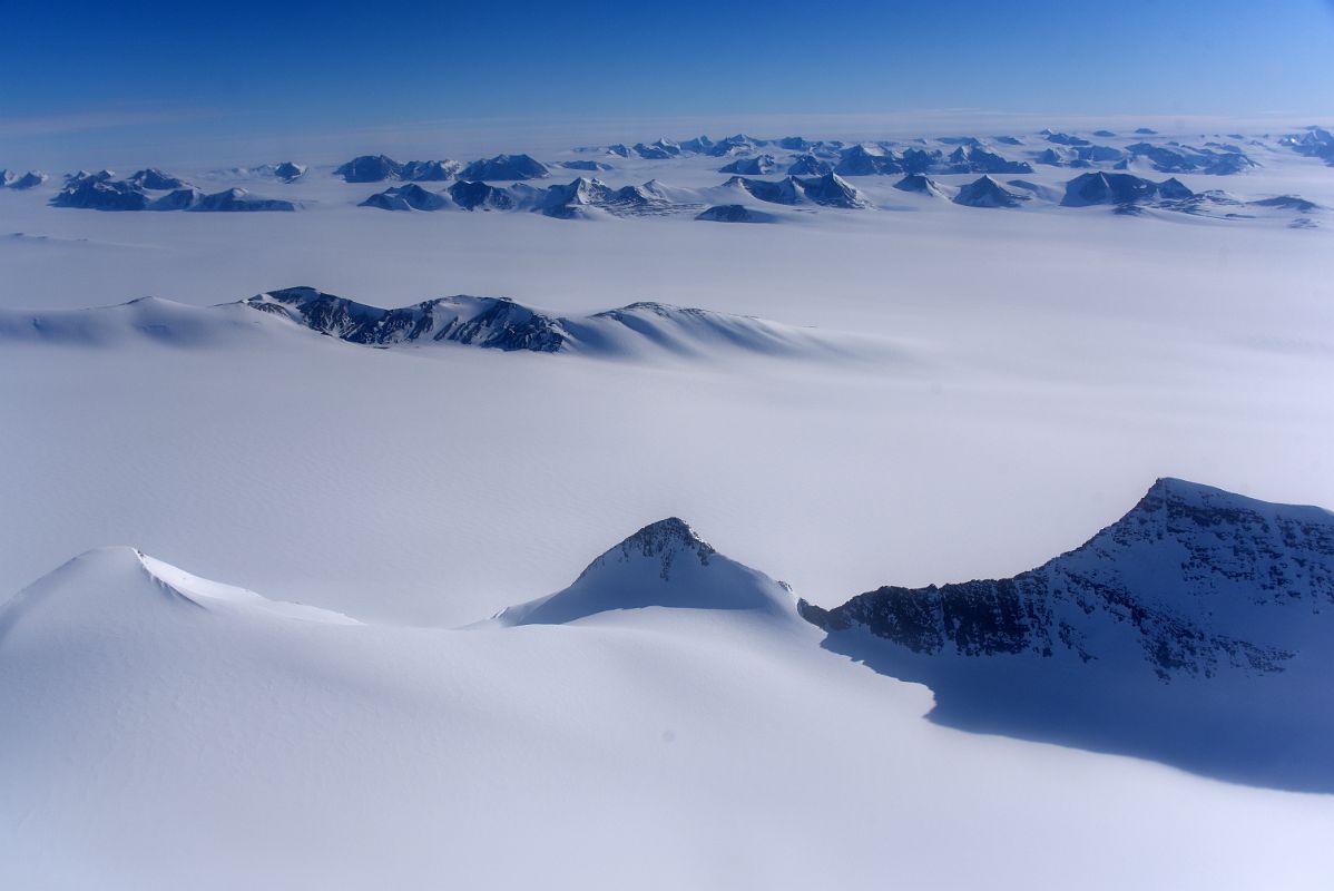 04C Mountains Pop Up From The Surrounding Glacier From Airplane Flying From Union Glacier Camp To Mount Vinson Base Camp